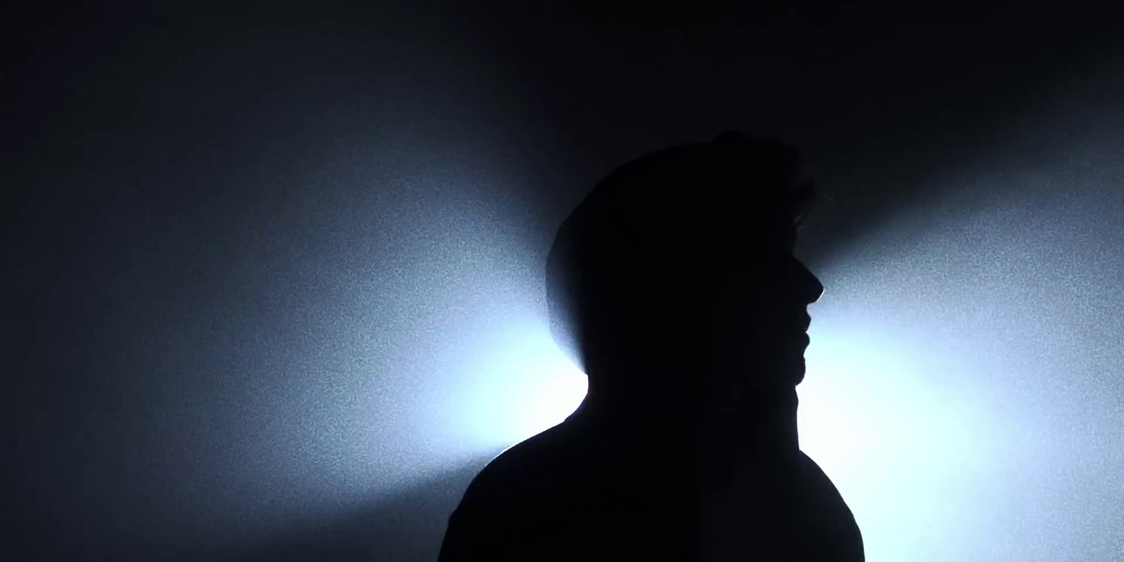 a silhouette of a man in a dark room