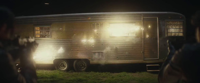 people standing in front of a trailer at night