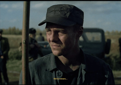 a man wearing a hat standing in front of a truck