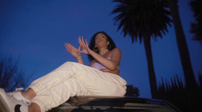 a woman sitting on the hood of a car