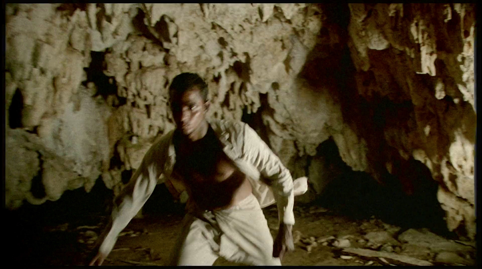 a man standing in front of a rock formation