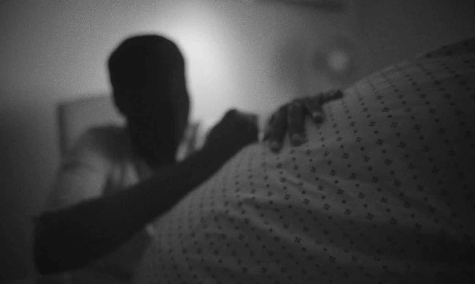 a black and white photo of a person in bed