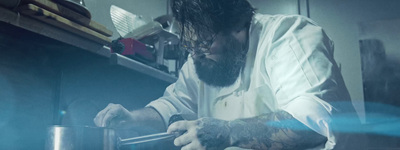 a man with a beard is cooking in a kitchen