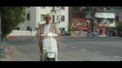 a man riding a white scooter down a street