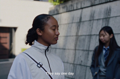 a woman standing next to a wall next to another woman