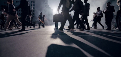 a group of people walking down a street next to tall buildings