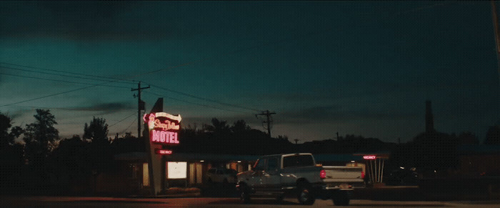 a truck is parked in front of a neon sign