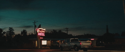 a truck is parked in front of a neon sign