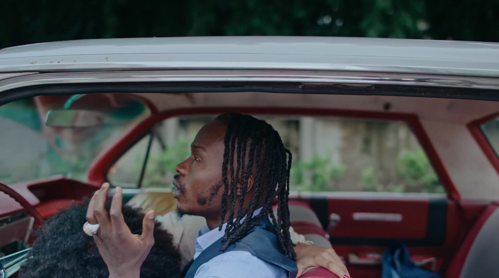 a man sitting in a car with a dog