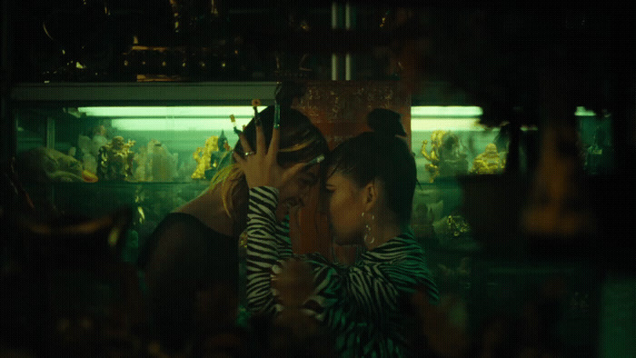 a couple of women standing next to each other in front of a fish tank