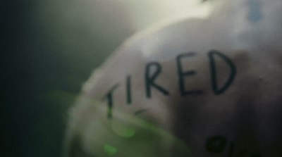 a close up of a stuffed animal with the word tired written on it