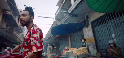 a man with dreadlocks walking down a street