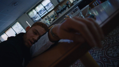 a man sitting at a table with a cigarette in his mouth