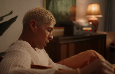 a man sitting on a couch looking at his cell phone