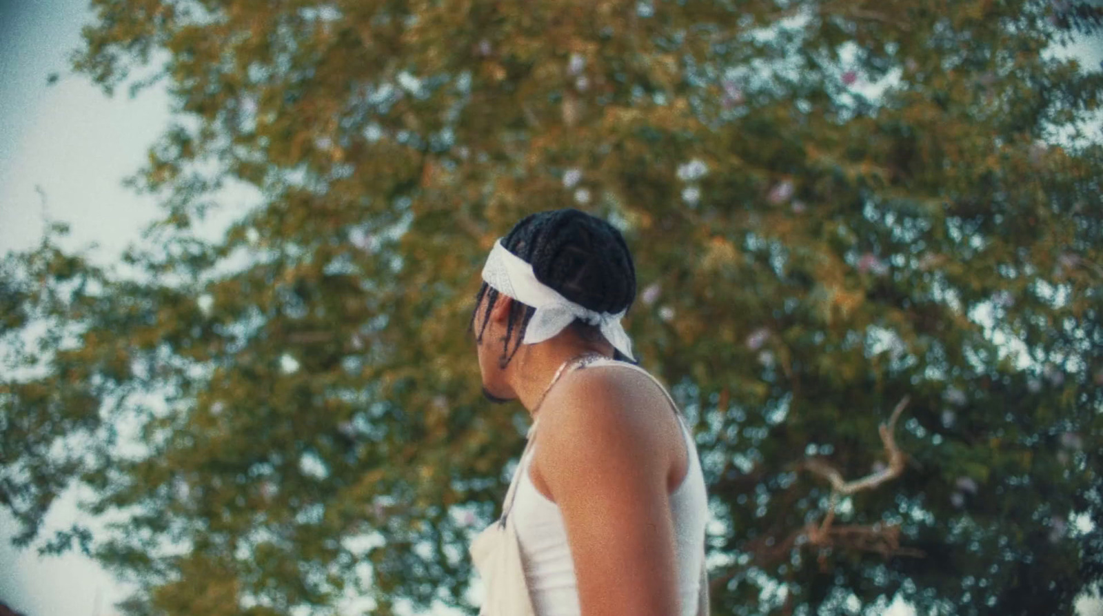 a woman in a white dress talking on a cell phone