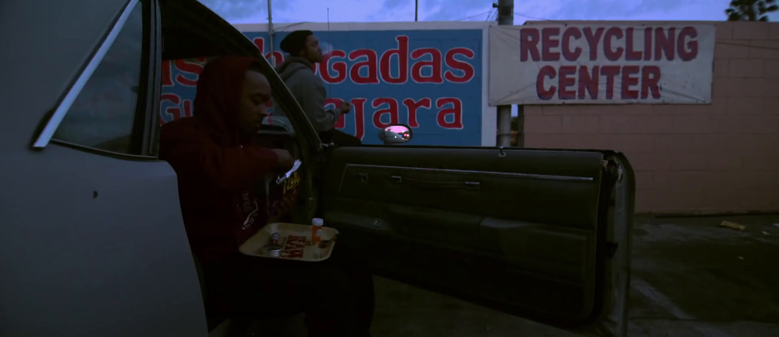 a woman in a red hoodie getting out of a truck