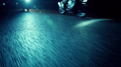 a person riding a motorcycle at night on a street