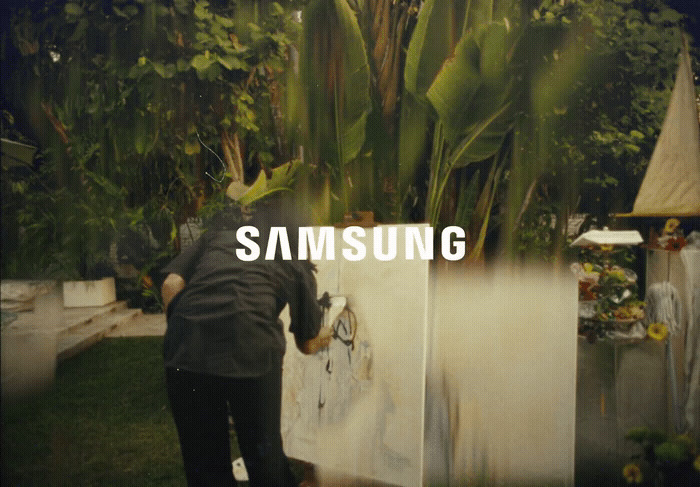 a man painting a picture with the words samsung on it