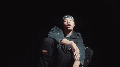 a man sitting on a skateboard in the dark