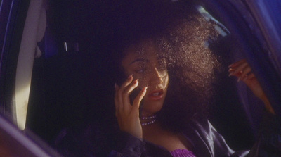 a woman sitting in a car talking on a cell phone