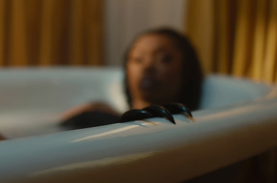 a woman laying in a bathtub with two black birds on it