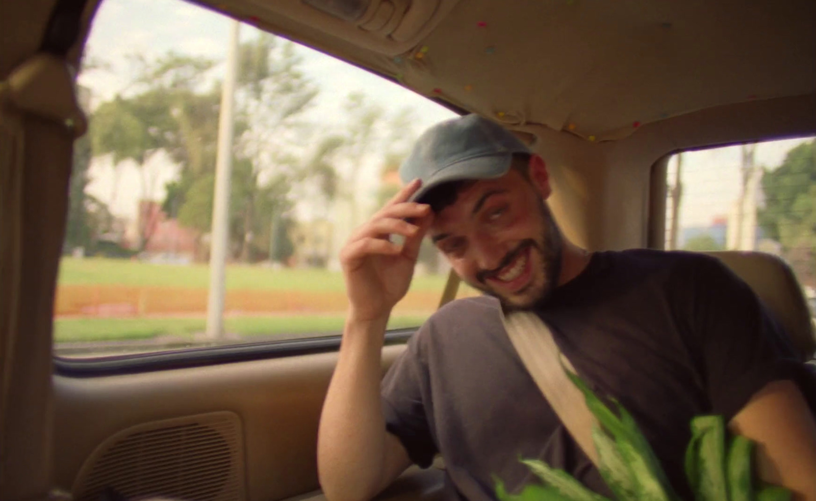 a man sitting in the back of a car talking on a cell phone