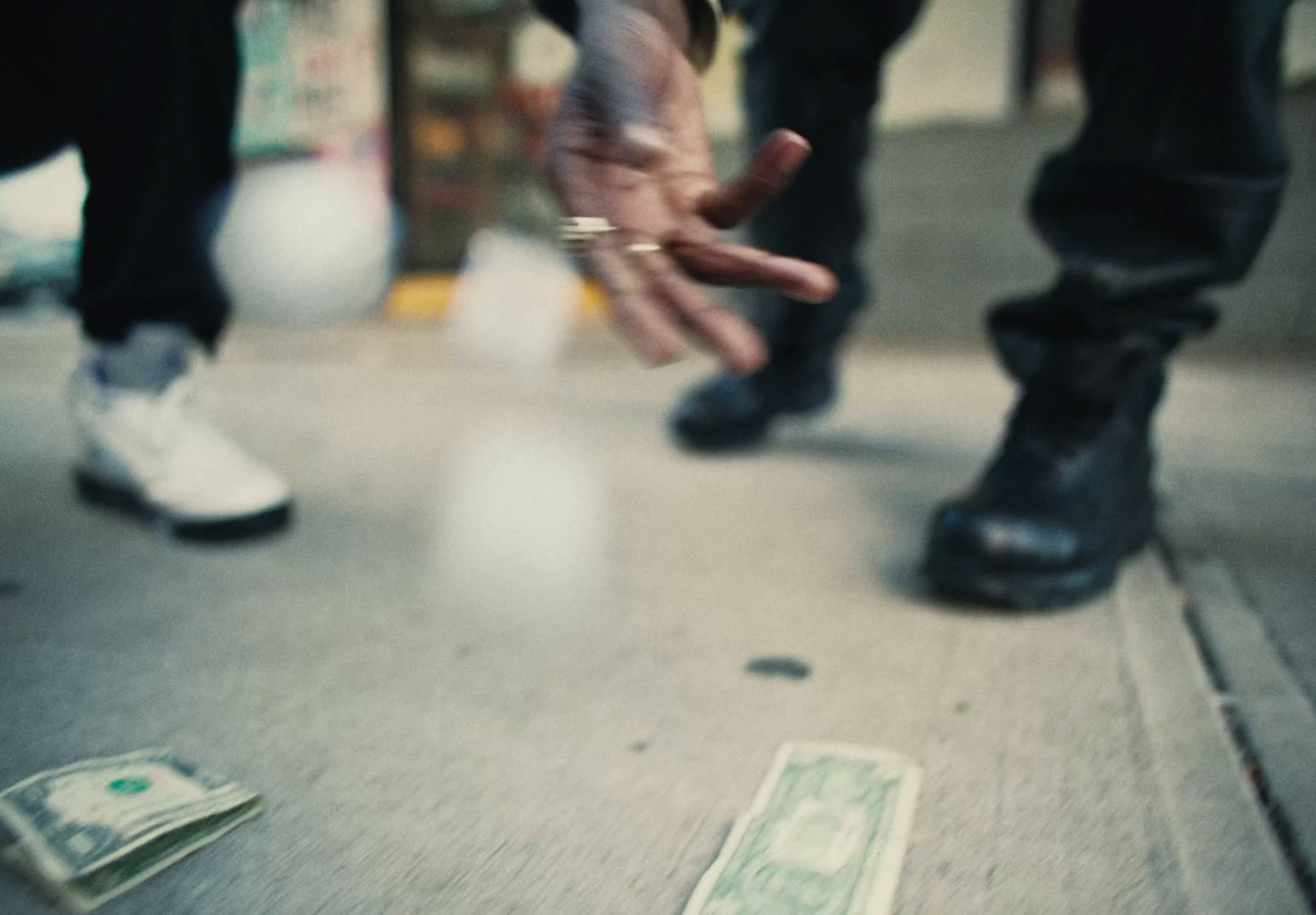 a person reaching for money on the ground