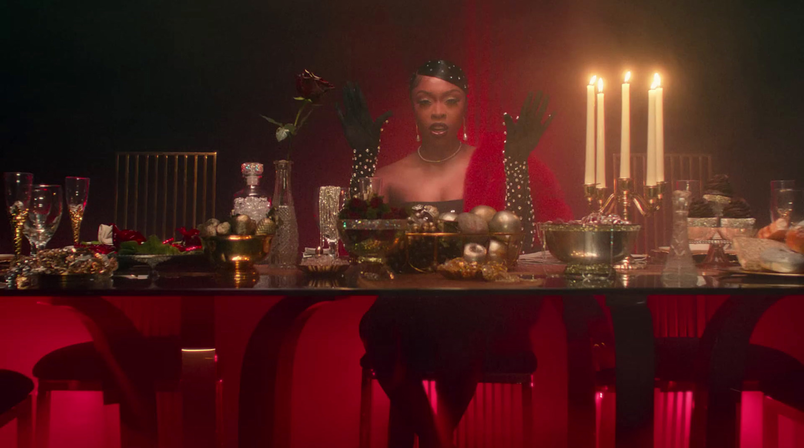 a woman sitting at a table surrounded by candles