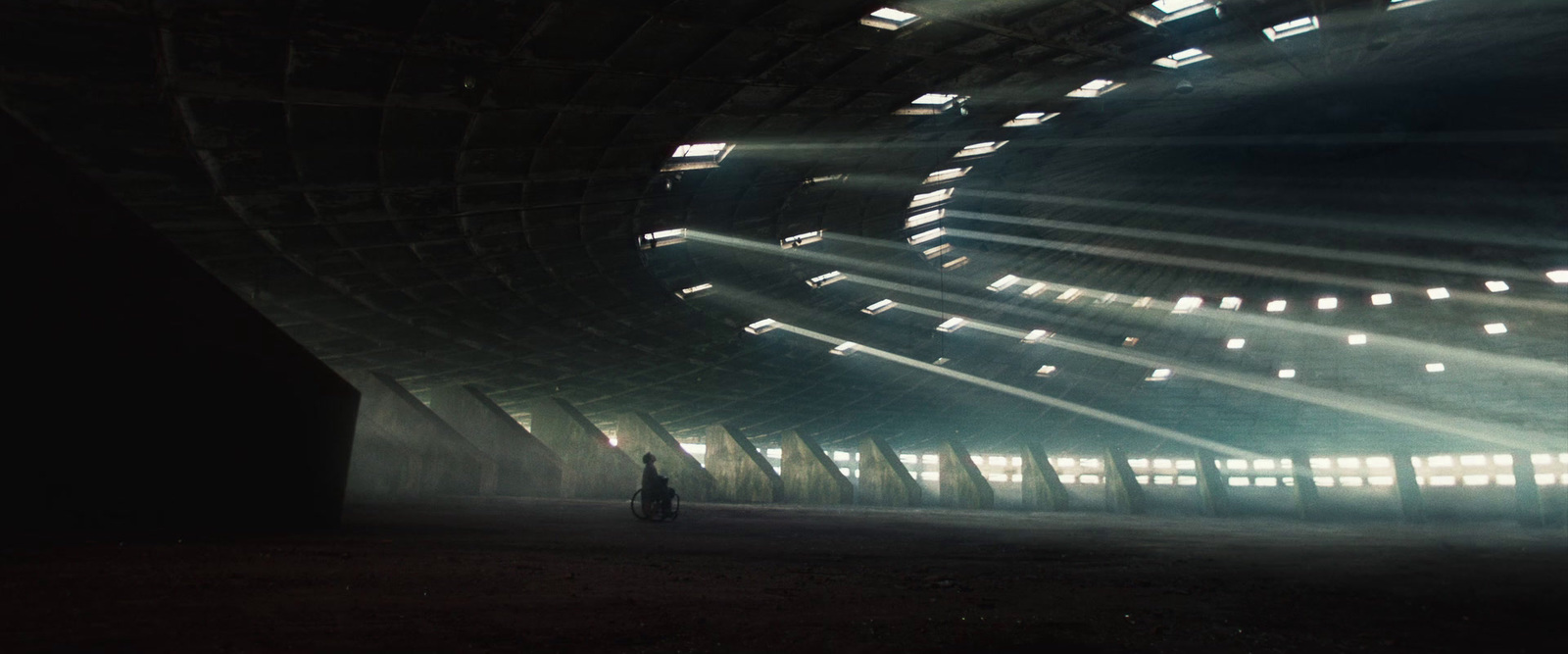 a person standing in a dark tunnel with bright lights