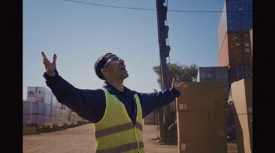 a man in a safety vest standing in front of a box