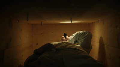 a person laying in a bed holding a remote control