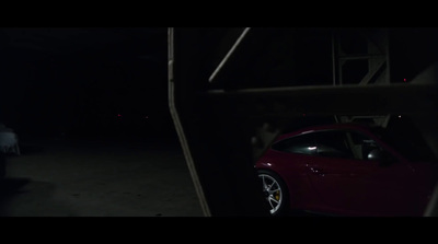 a red car parked in a dark parking lot