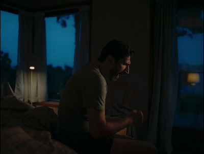 a man sitting on a bed in a dark room