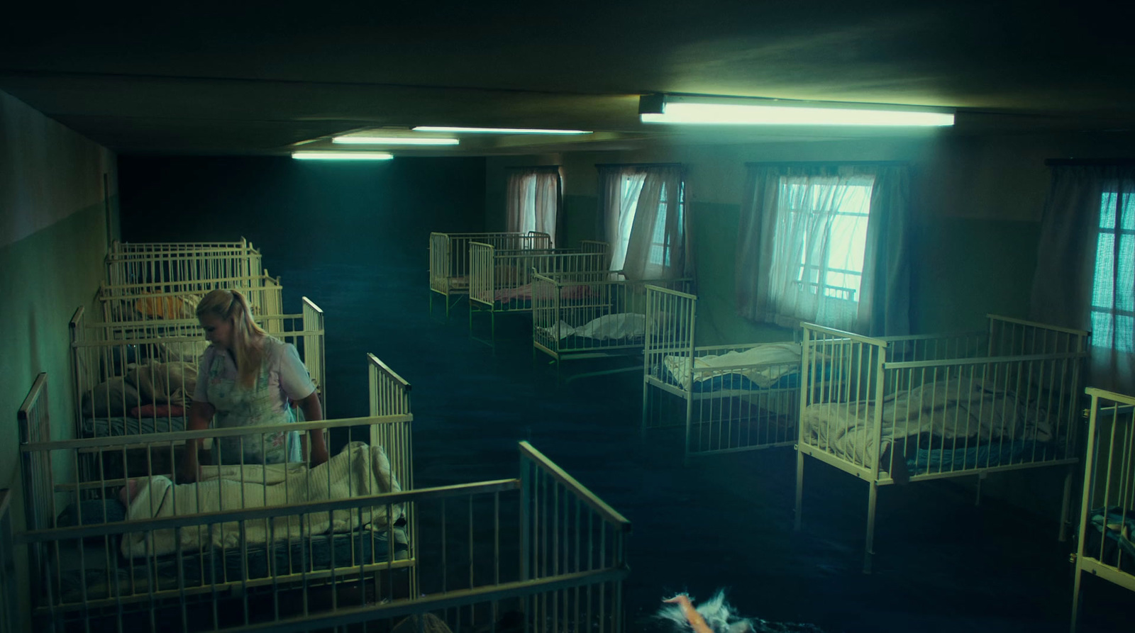 a woman standing in a room filled with bunk beds