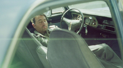 a man sitting in a car with a steering wheel