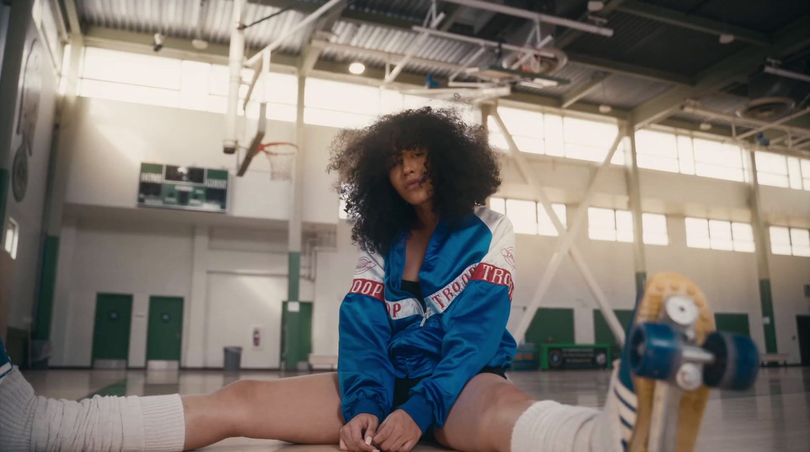 a woman sitting on the floor in a gym