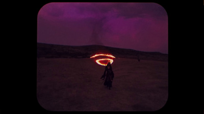 a person standing in a field holding a fire ball