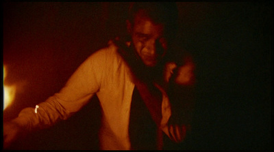 a man standing in a dark room with his hands on his hips