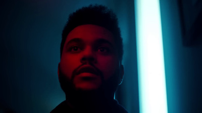 a man standing in a dark room with a red light behind him