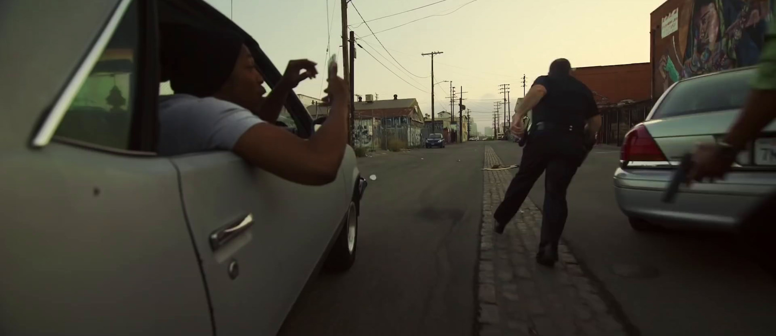 a woman walking down a street next to a car