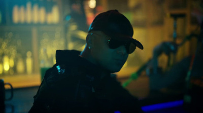 a man wearing sunglasses and a hat in a dark room