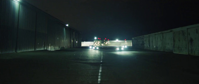 a truck driving down a street at night