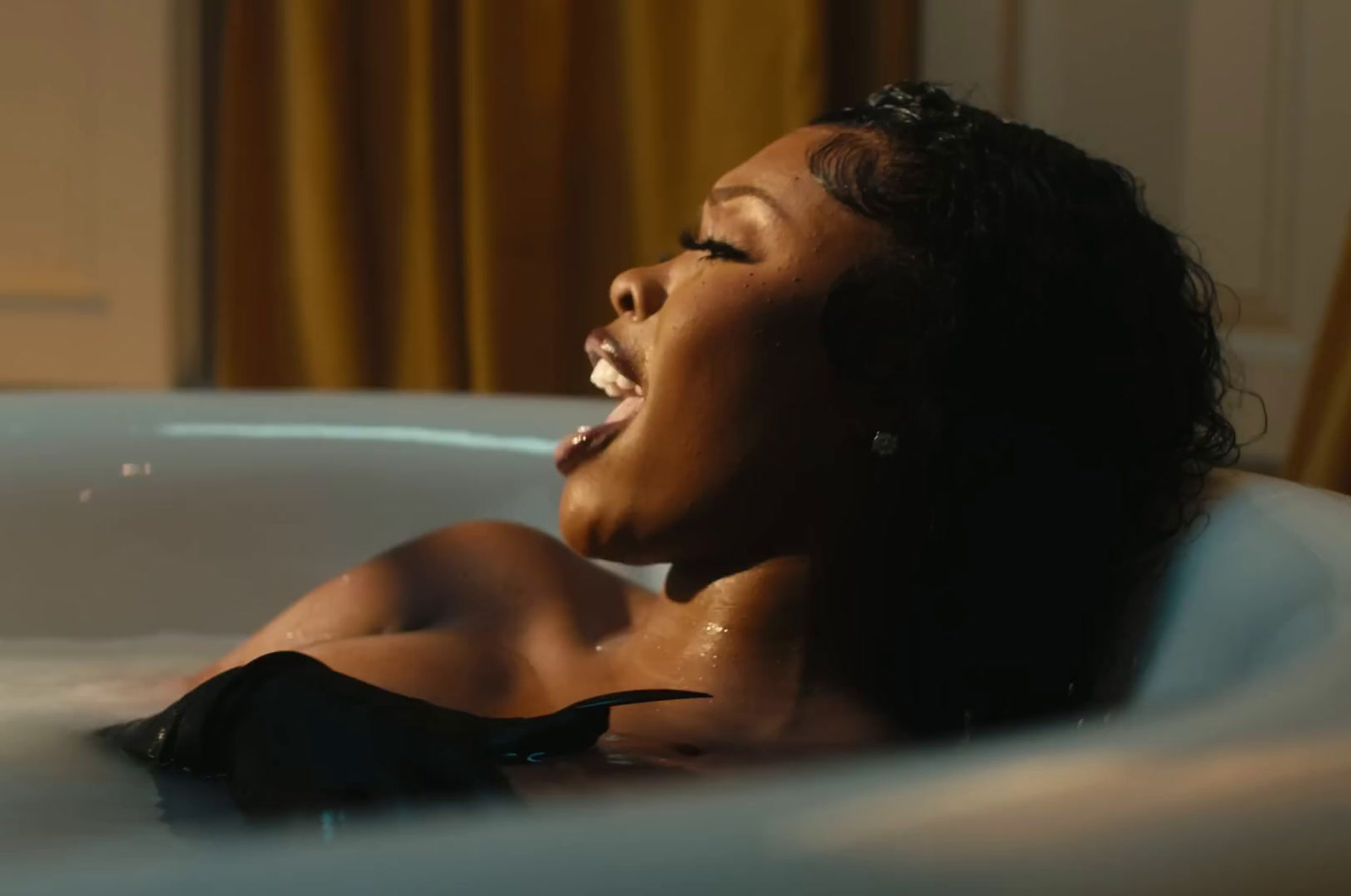 a woman sitting in a bathtub with her mouth open