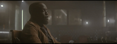 a man sitting in a chair in a dark room