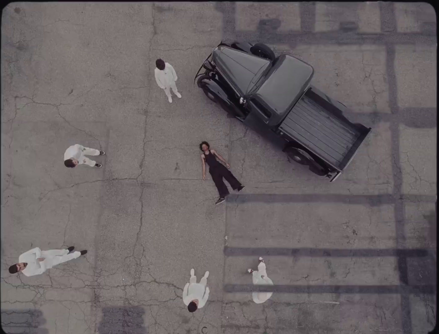 a group of people standing around a parked car