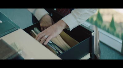 a person holding a drawer full of files