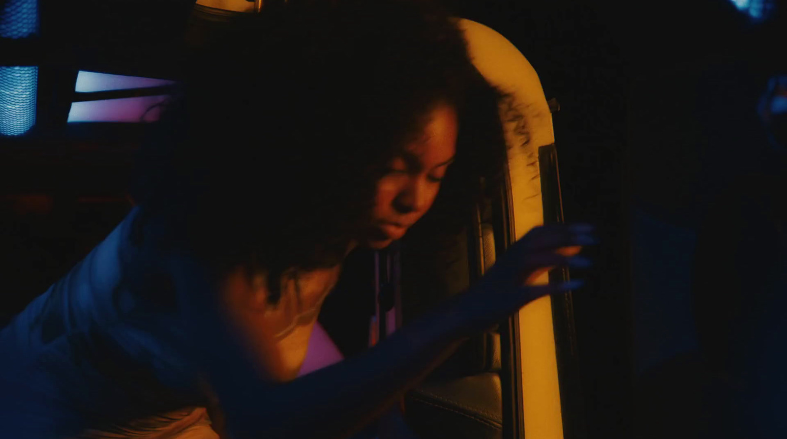 a woman looking into a microwave in a dark room