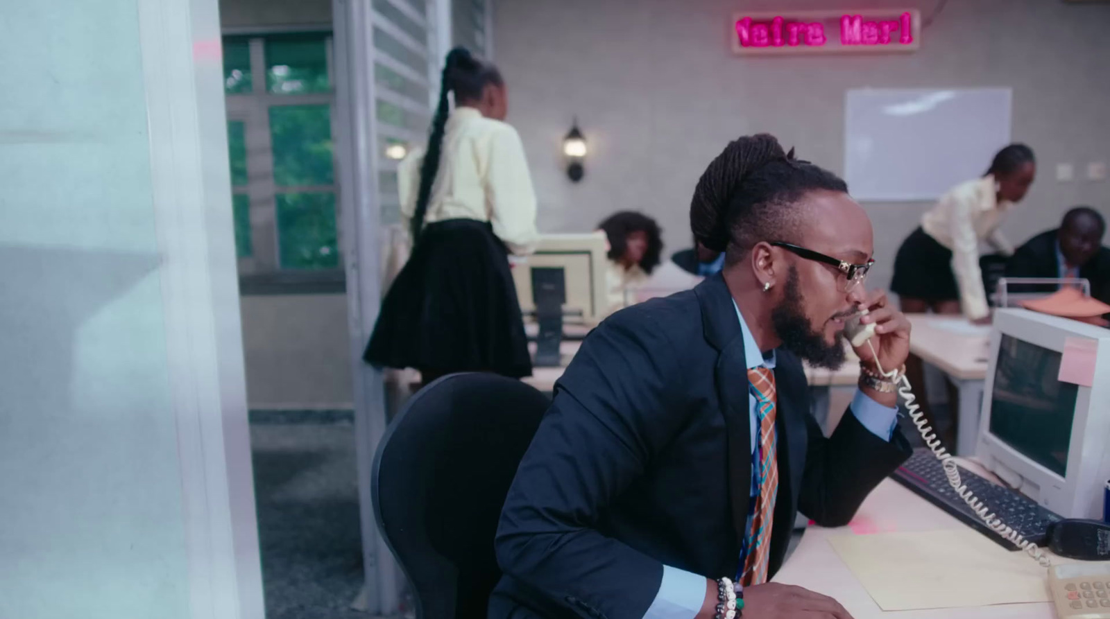 a man sitting at a desk talking on a phone