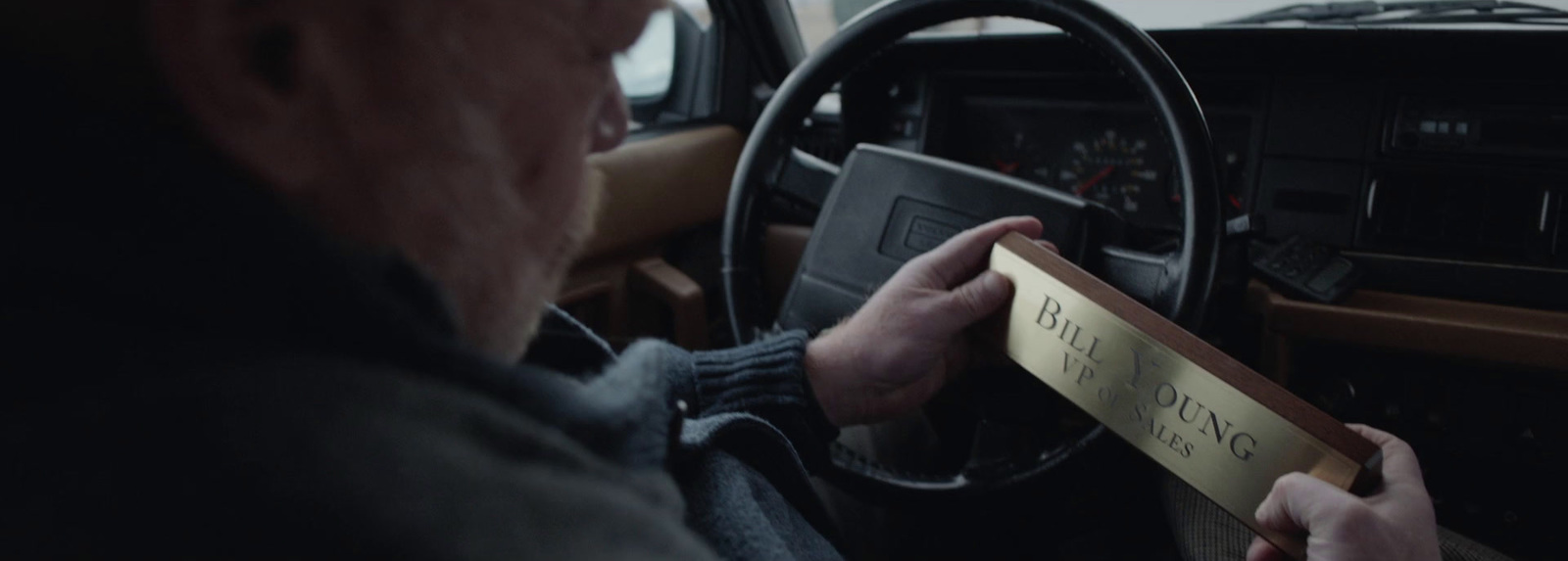 a man driving a truck holding a sign in his hand