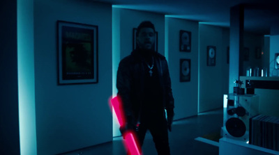 a man standing in a dark room holding a neon stick